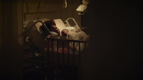 Woman And Newborn Baby Resting In Hospital Bed