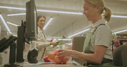 Employée de supermarché d'âge mûr travaillant à la caisse pour servir un client