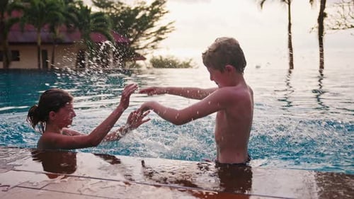 Boy Splashing Girl With Pool Water