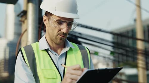 Portrait of Man Engineer Tracking Project Milestones Standing on Construction Site