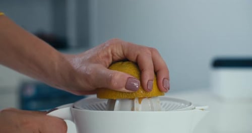 Squeezing Fresh Orange Juice on a Kitchen Counter