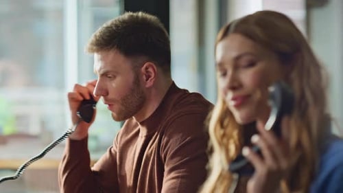 Woman and Man Talking on the Phone at Work