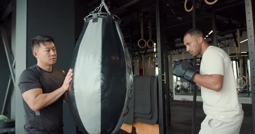 Ein männlicher Boxer übt seine Bewegungen mit seinem Trainer