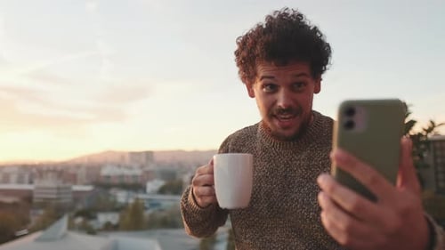 Smiling Man Video Chats and Drinks Coffee