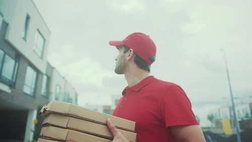 Courier Stops Outside Apartment Building Focused Delivery Person Pausing Amidst Urban Environment