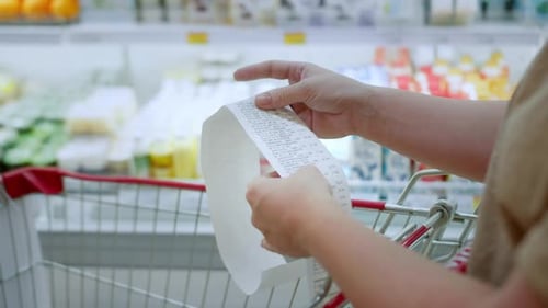 Woman Checks Paper Check After Shopping for Groceries at Mall By Checking Dear Amount Bill in a