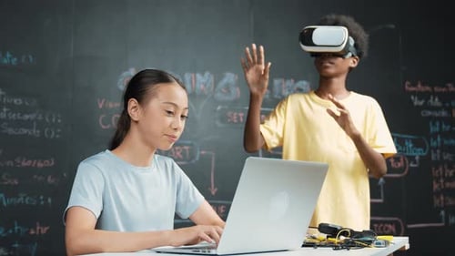 Jungen tragen ein Headset, um in das Metaversum einzutreten, während der Schüler ein Programm schreibt. Erbauung