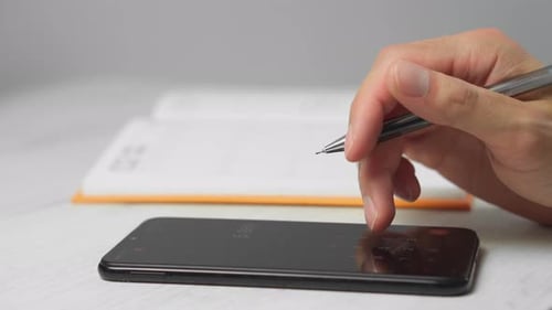 Hand Uses Calculator App on Smartphone