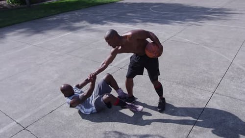 Street basketball player helps rival after hard foul on city court