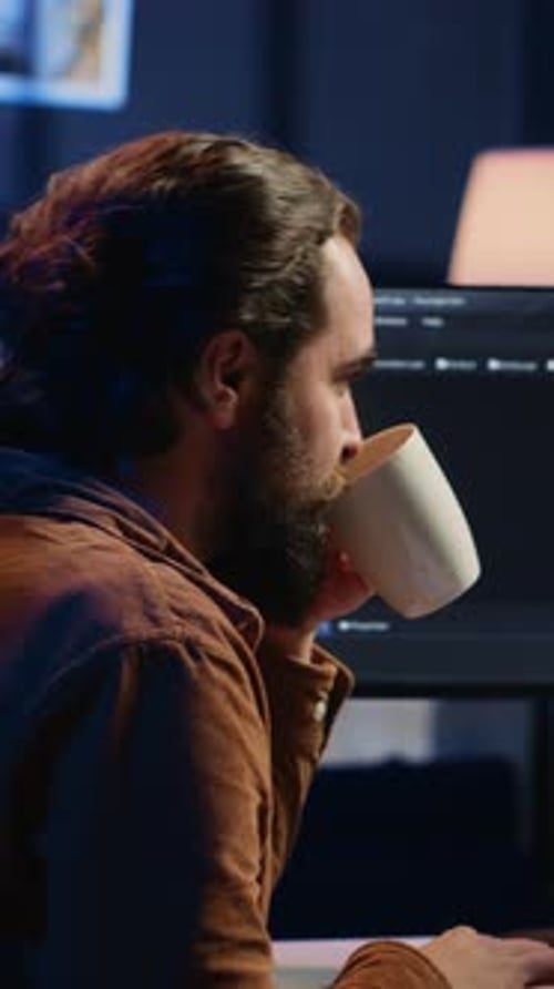 Man Working at Computer Typing Code at Night