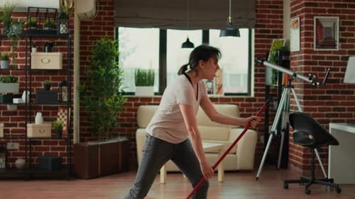 Woman Energetically Plays Mop Like Guitar at Home