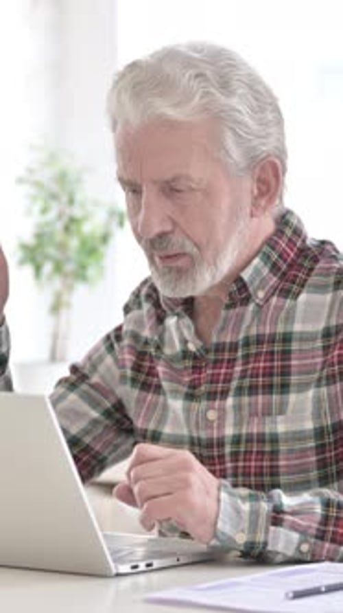 Senior Man Video Calling on Laptop at Home