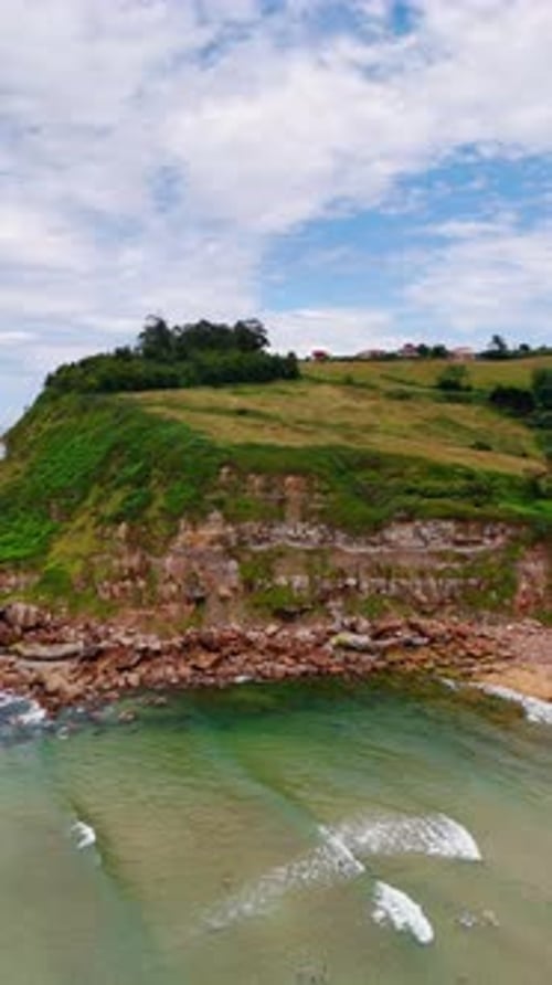People stand in the shallow transparent water at the sandy beach.