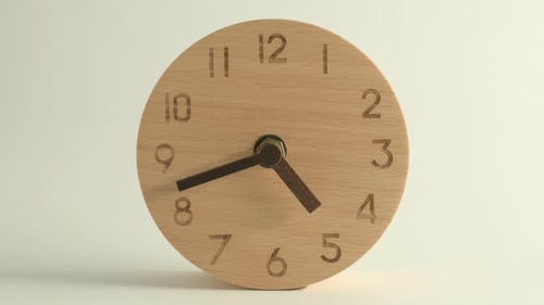 The wooden alarm clock on a white background, in the style of time lapse video.
