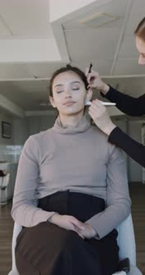 Détails de la séance de maquillage Un maquilleur professionnel prépare un modèle avec des coups de pinceau délicats