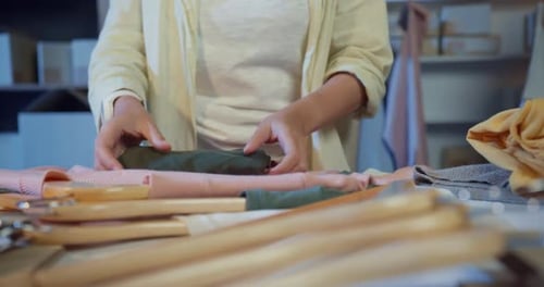 Perfect Folding Technique Woman Neatly Organizing Clothes or Fabric in Workshop