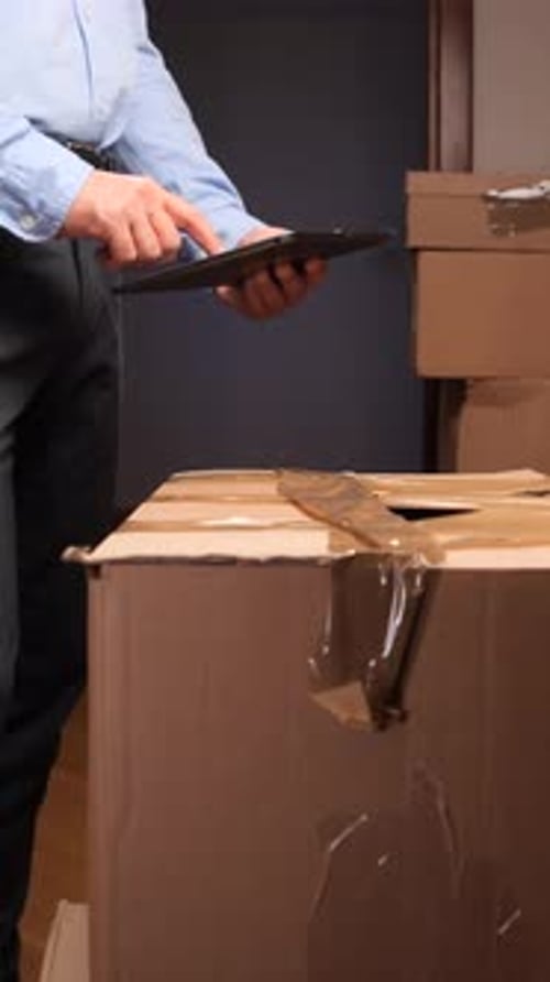 Vertical Video Delivery Man Managing Logistics Using Digital Tablet