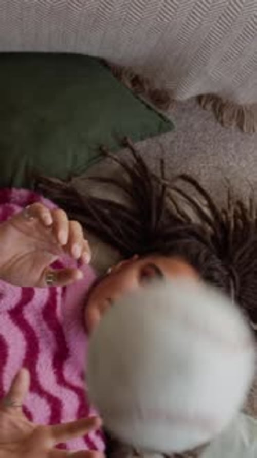 Young Woman Lying Down Tossing Baseball