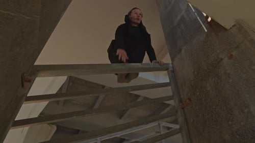 Person Climbing Steep Urban Stairwell