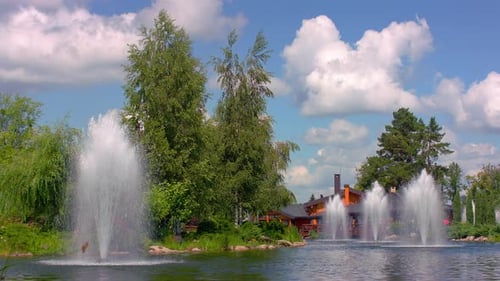 Springbrunnen im Stadtpark. Naturlandschaft mit grünen Bäumen, See, Springbrunnen und