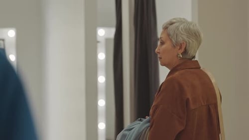 Elegant Woman Enters Dressing Room in Boutique