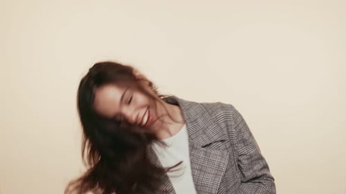 Energetic Young Brunette Woman Dancing in Studio with Trendy Attire