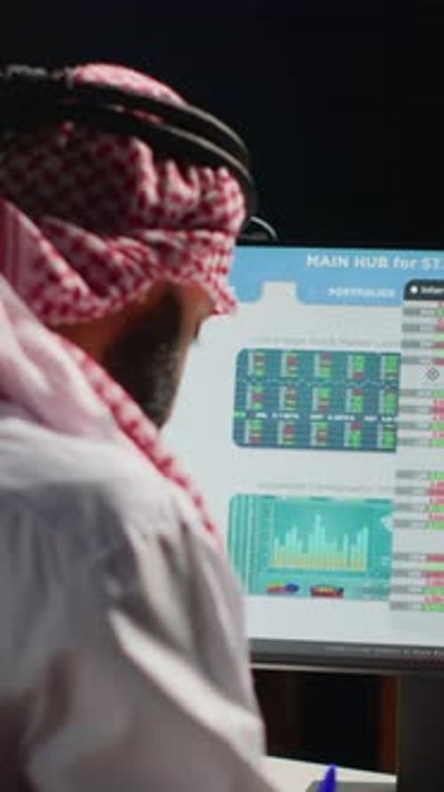 Man At Computer Analyzing Stock Market Data