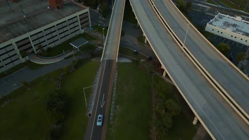 Drone suspenso se inclina ao longo da rampa da rodovia que leva ao centro de Tampa durante a Hora Dourada