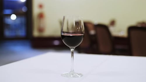 Elegant and clean goblet of red wine on a restaurant table. Portrait of glass of wine