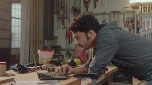 Woodworker Using Laptop in Carpentry Workshop