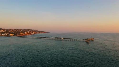 Scenic Ocean Beach pier with vibrant sunset colors during golden hour, aerial wide shot.