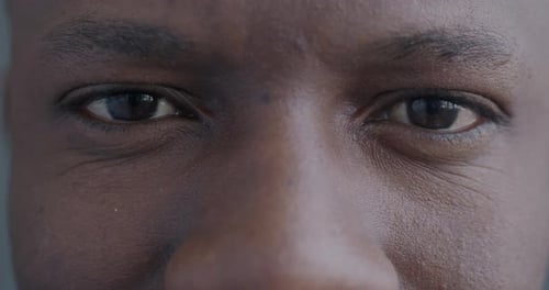 Closeup Slow Motion Portrait of Cheerful African American Man's Eyes Smiling