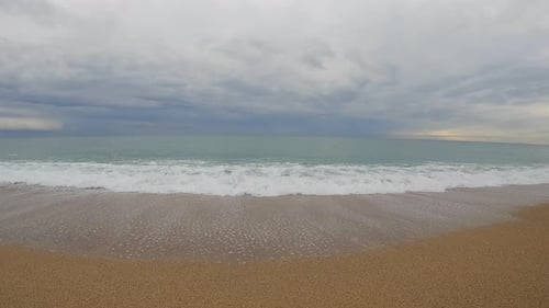 Coarse sand beach sea wave in slow motion at 120fps 4k cloudy day turquoise water single sea waves B