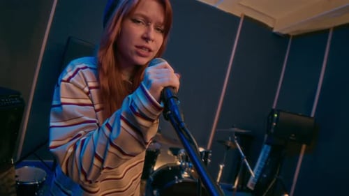 Portrait of Punk Girl in Striped Sweater Singing Rock Song in Music Studio