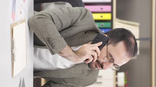 Man Talking on Phone in Office Setting