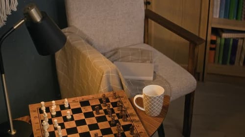 Chessboard and Coffee Cup on Table near Chair