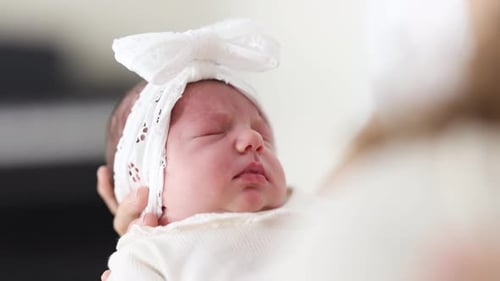 Sweet Newborn Infant Sleeping Peacefully in Arms