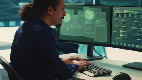 Man Working at Computer with Dual Monitors