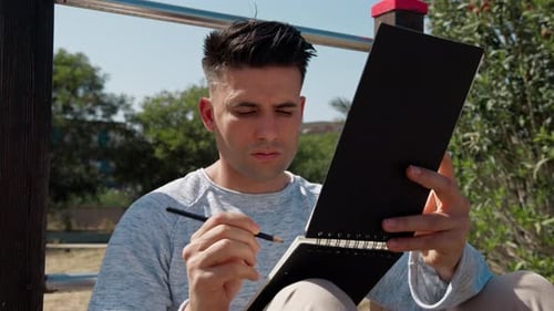 Student Writing Notes In The Park