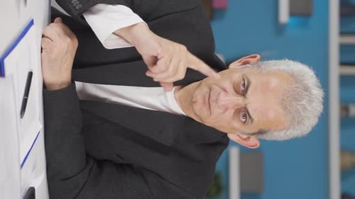 Vertical video of Home office worker man looking at camera with a stern angry warning.