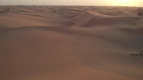 Aerial view from drone flying towards the sunset in Abu Dhabi desert, United Arab Emirates