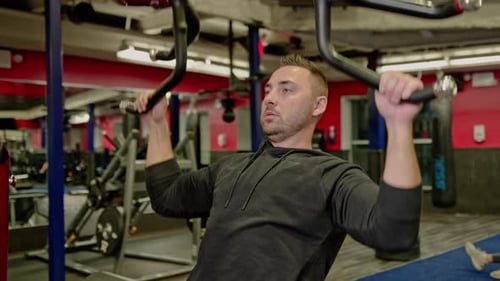 Muscular Man Actively Training in the Modern Gym
