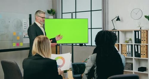 businessman talking with successful man and woman colleagues while he standing near green screen