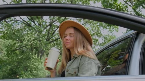 Blonde Woman Stoped on Road Next to Car and Drink Coffee or Tea From Reusable Mug Slow Motion Refuse