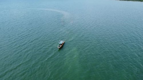 View of fishing boats sailing on the sea with mountains and clouds in the background
