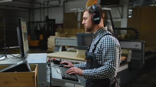 Man Using Computer in Modern Factory