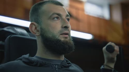 Portrait of Athletic Man Starting to Workout on Machine in Gym