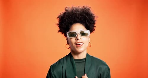Black woman, sunglasses and smile for fashion in studio background, trendy clothes and bold style