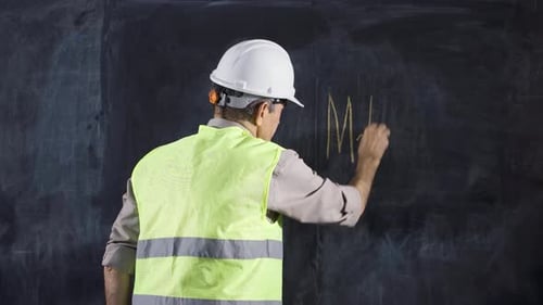 Engineer man writes Milling on the blackboard.