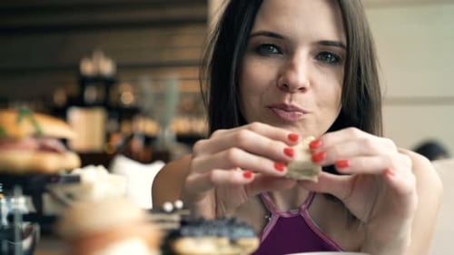 Young woman enjoying a delicious sandwich at a relaxing cafe in the city
